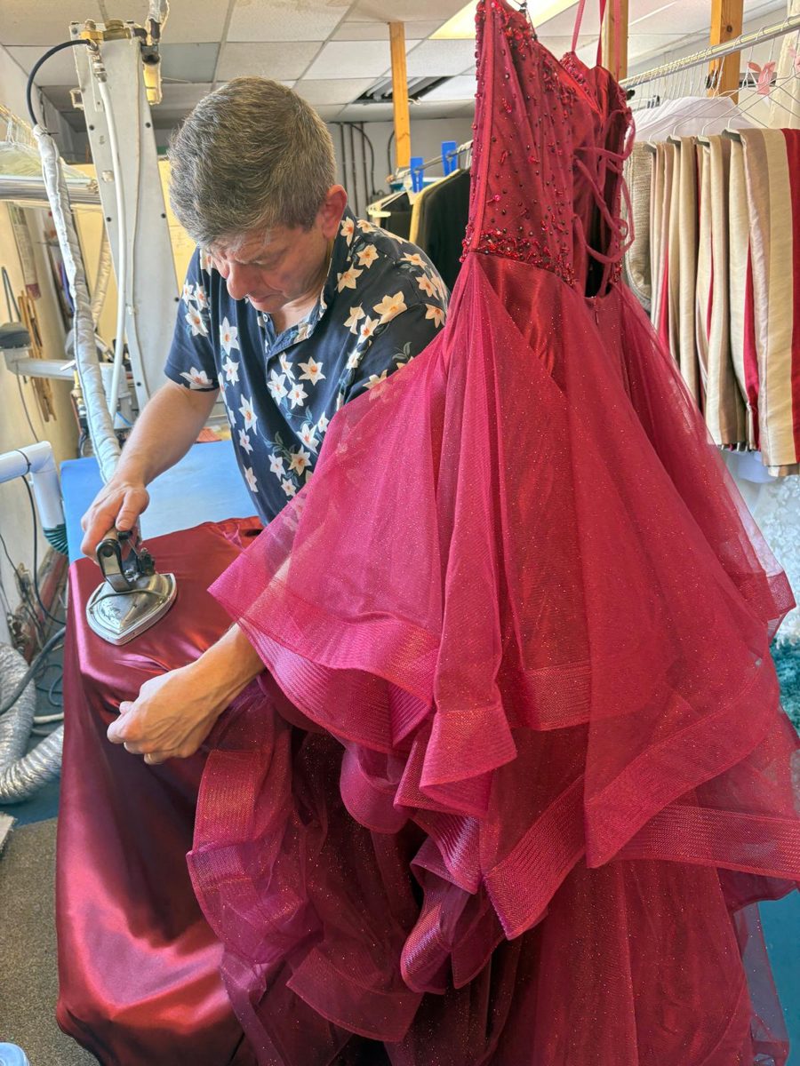 Paul steaming a magenta prom gown by hand in the Tudor Dry Cleaners workroom